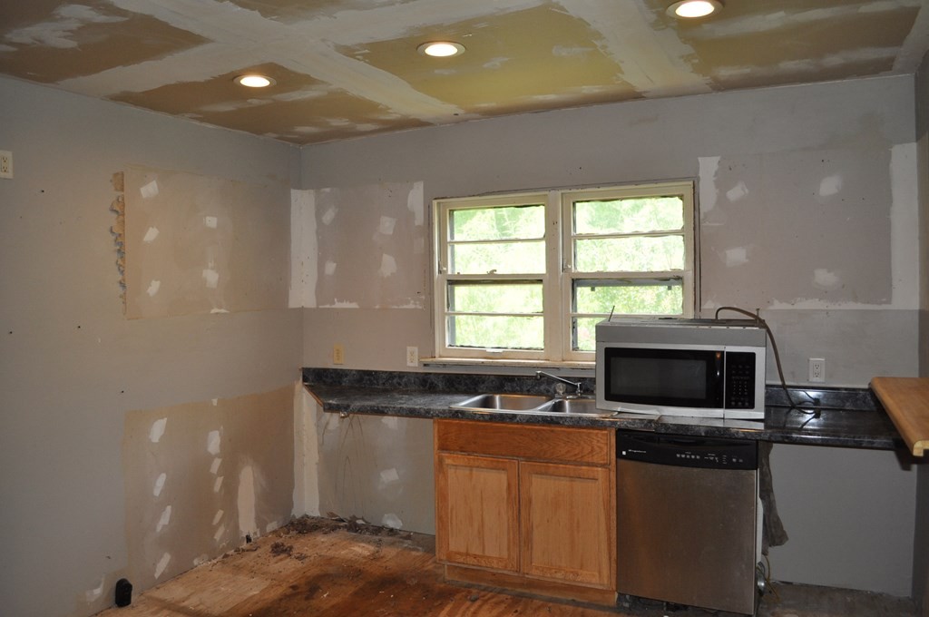 1829 Freeport Road Northwest Dalton, GA 30720 - Photo 3 of 5 a kitchen with stainless steel appliances granite countertop a stove a sink and a microwave