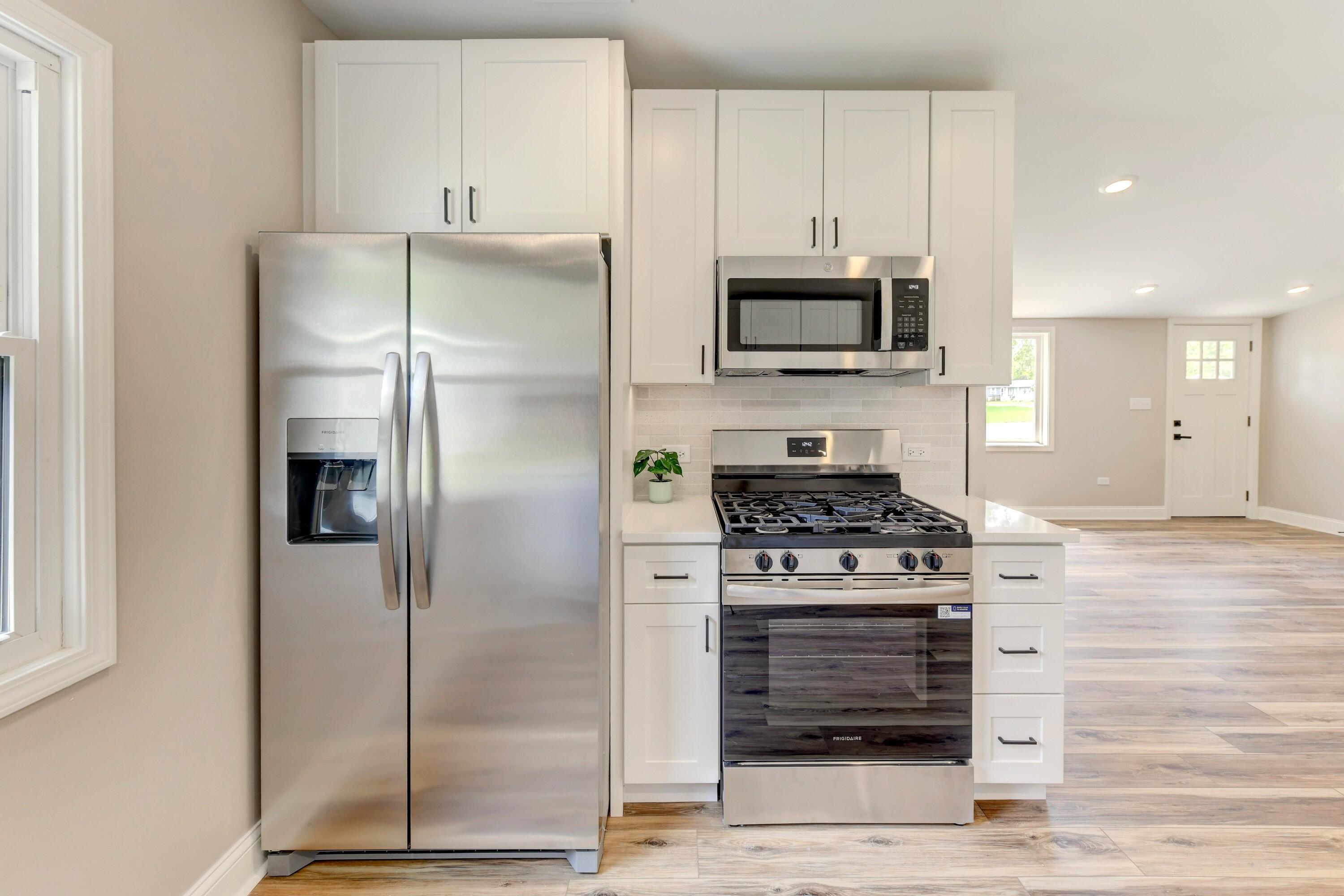 3908 West 127th Place Crown Point, IN 46307 - Photo 5 of 18 a kitchen with stainless steel appliances granite countertop a stove a refrigerator and a microwave