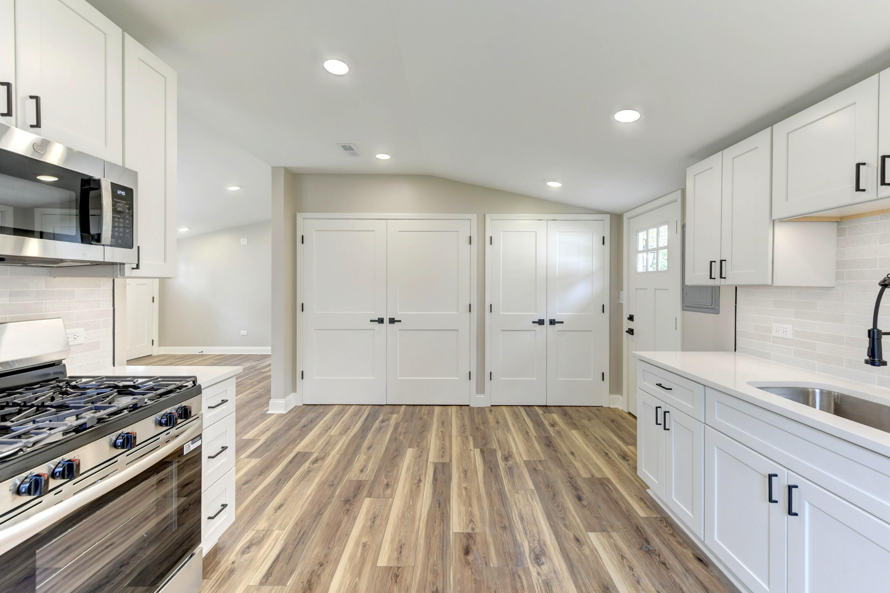 3908 West 127th Place Crown Point, IN 46307 - Photo 6 of 18 a large kitchen with a stove and a sink