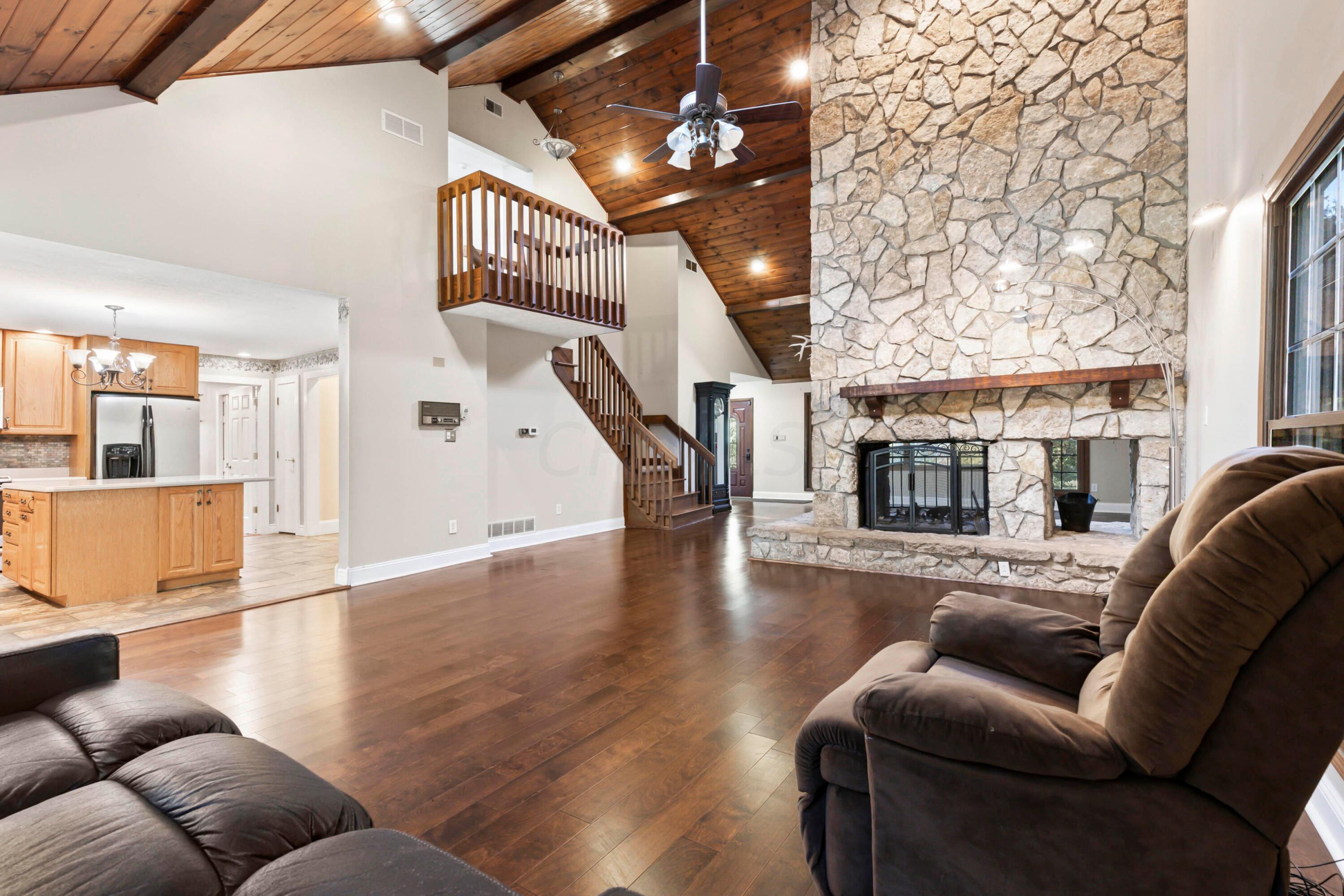9495 Kilbourne Road Sunbury, OH 43074 - Photo 13 of 84 • New engineered hardwood
flooring May 2017
• Tan painted walls
• Wood paneled, vaulted ceiling
• Decorative ceiling beams
• Floor to ceiling, see-through
stone fireplace
• Skylight
• Can lighting
• Lighted ceiling fan
• Access to In-Law Suite/
Bonus Room
