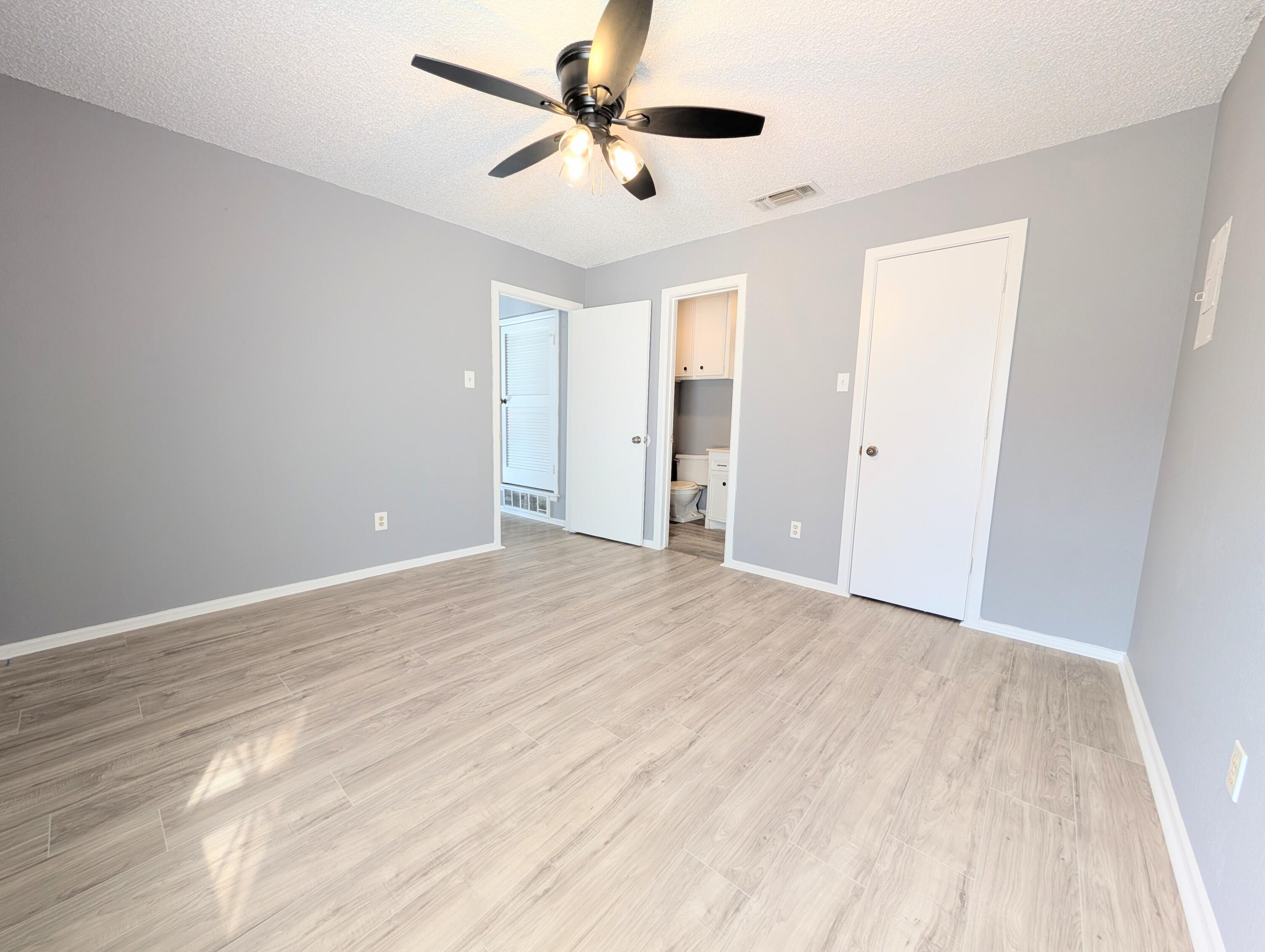 6108 37th Street, Unit A Lubbock, TX 79407 - Photo 5 of 8 a view of empty room with wooden floor