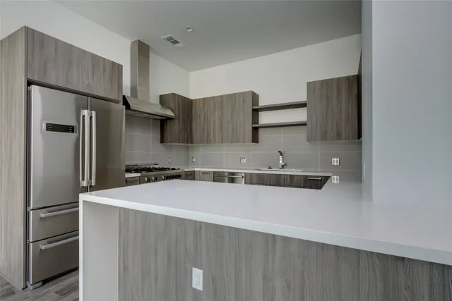 a kitchen with stainless steel appliances a refrigerator and a sink