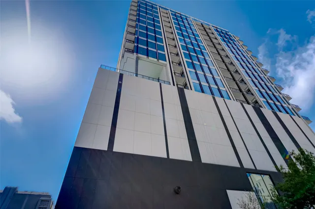 a living room with patio furniture and floor to ceiling windows