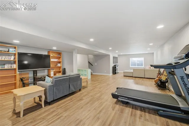 a living room with furniture flat screen tv and wooden floor