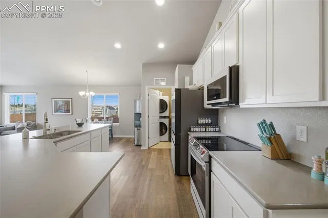 a kitchen with a sink a counter top space stainless steel appliances and cabinets