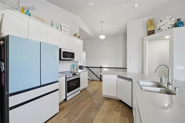 a kitchen with kitchen island a counter top space a sink stainless steel appliances and cabinets