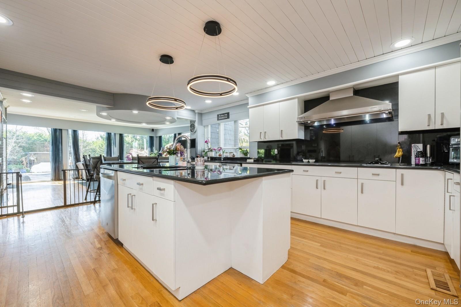 123 Barrett Road Lawrence, NY 11559 - Photo 7 of 32 a kitchen with stainless steel appliances granite countertop a refrigerator a sink dishwasher a stove and white countertops with wooden floor