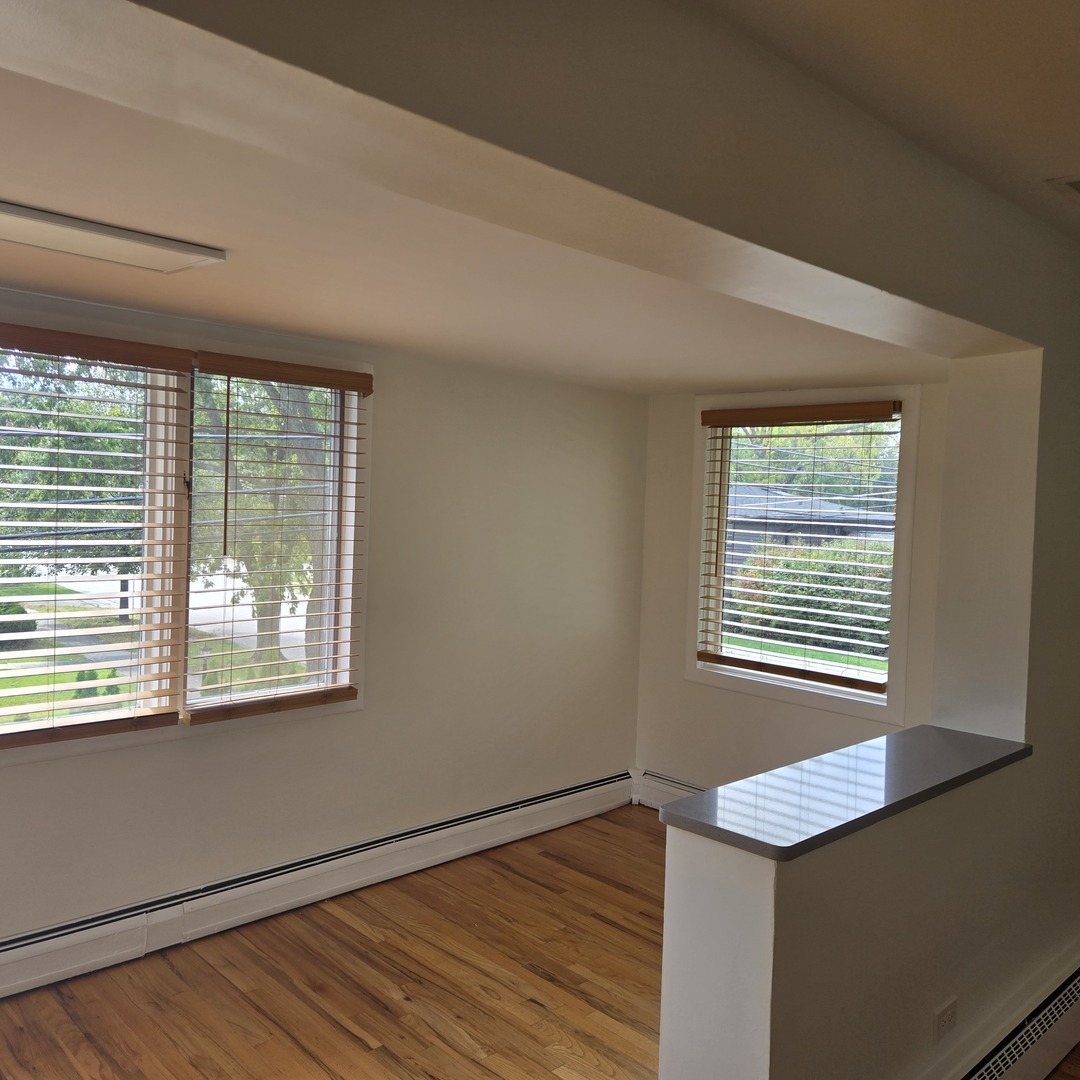 1817 West Touhy Avenue, Unit 2E Park Ridge, IL 60068 - Photo 14 of 19 a view of an empty room with wooden floor and a window