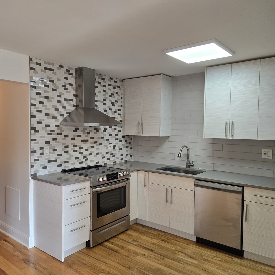 1817 West Touhy Avenue, Unit 2E Park Ridge, IL 60068 - Photo 4 of 19 a kitchen with granite countertop a sink cabinets and stainless steel appliances