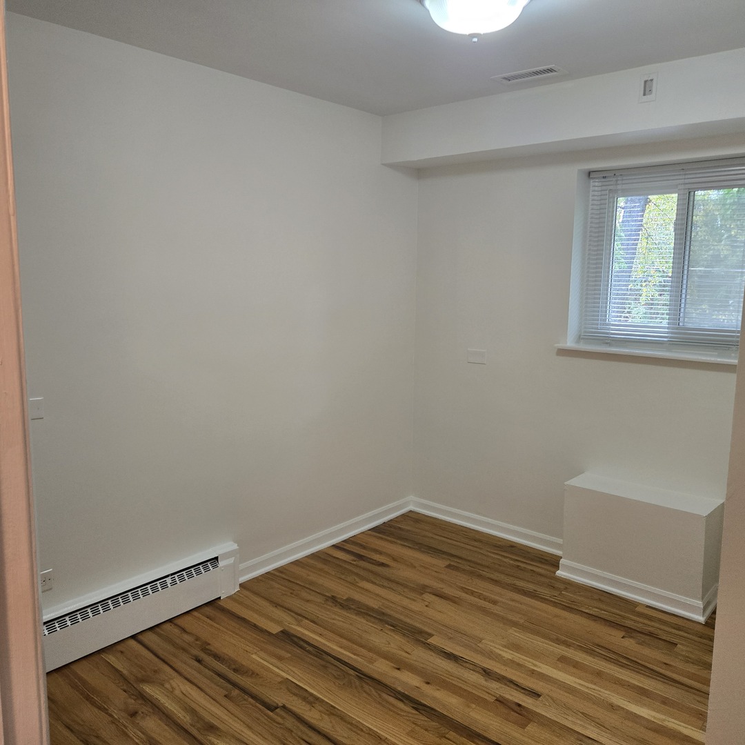 1817 West Touhy Avenue, Unit 2E Park Ridge, IL 60068 - Photo 10 of 19 a view of a room with wooden floor and small window