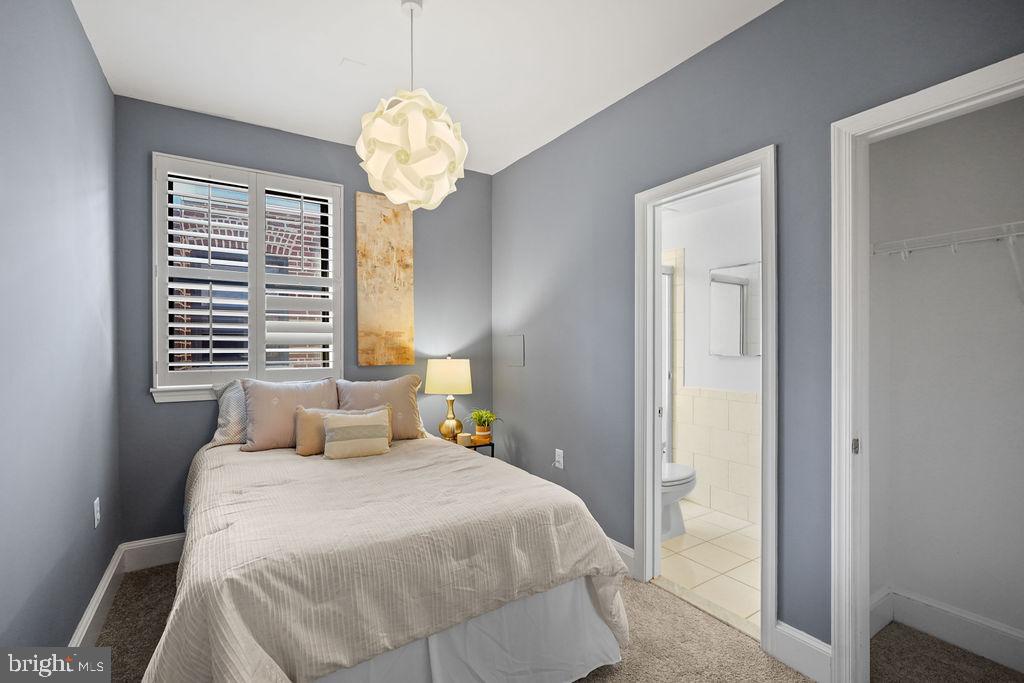 1419 Clifton Street Northwest, Unit 304 Washington, DC 20009 - Photo 12 of 22 a bedroom with a bed and a chandelier