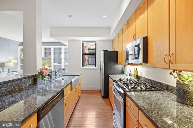 a kitchen with stainless steel appliances granite countertop a sink stove and refrigerator