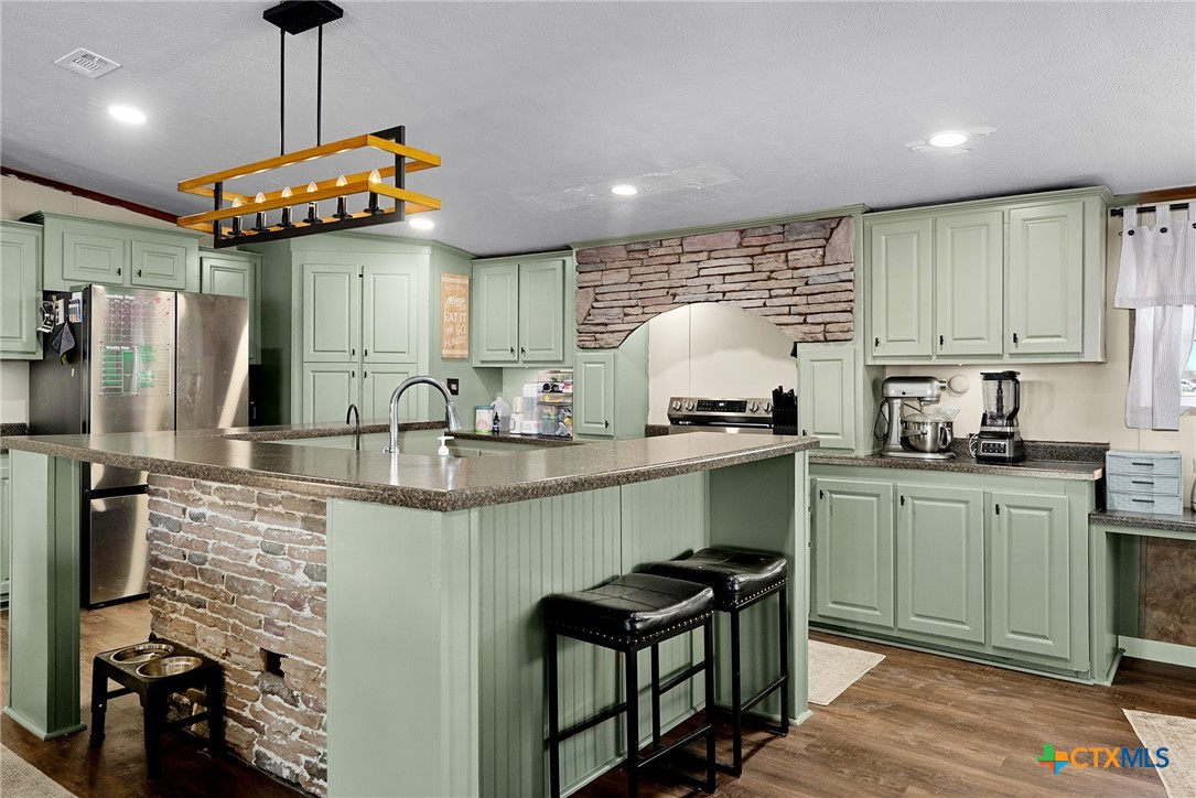 2850 Woodrow Center Road Kingsbury, TX 78638 - Photo 4 of 33 a kitchen with stainless steel appliances granite countertop a sink a stove and refrigerator