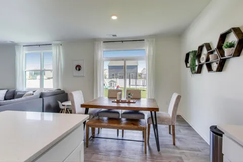 a living room with stainless steel appliances kitchen island granite countertop a dining table chairs and a kitchen view