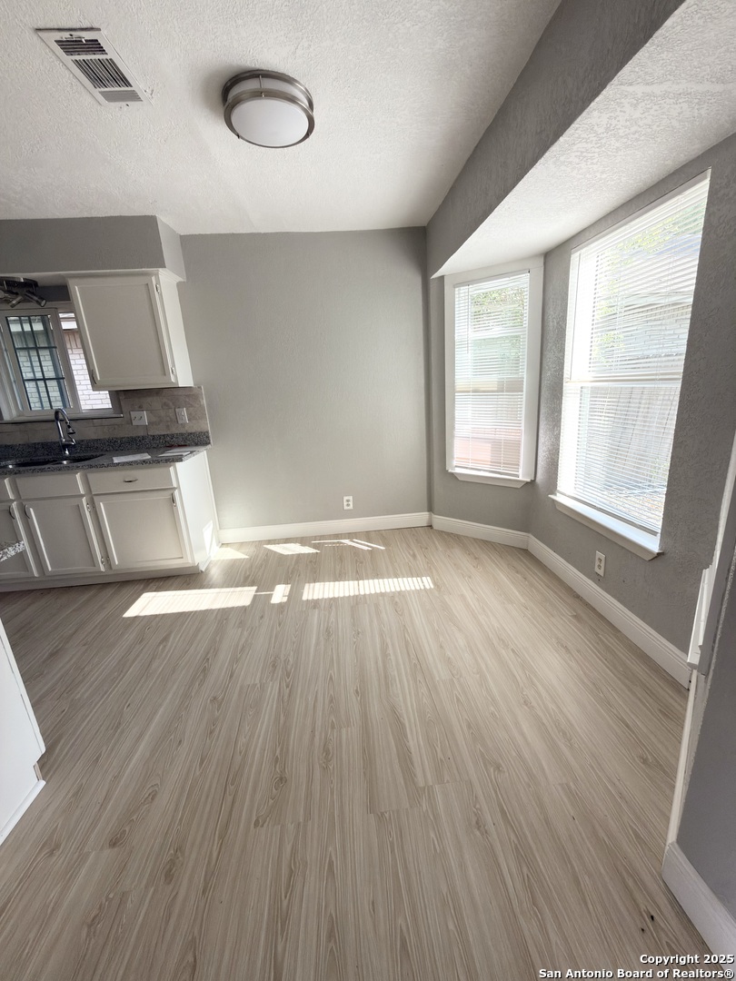 14519 Ridge Meadow Drive San Antonio, TX 78233 - Photo 11 of 25 an empty room with wooden floor and windows