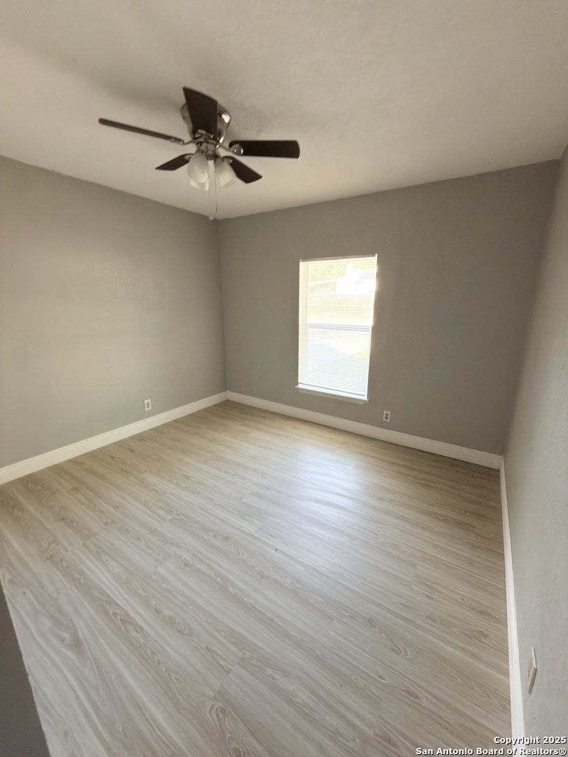 14519 Ridge Meadow Drive San Antonio, TX 78233 - Photo 12 of 25 an empty room with wooden floor fan and windows