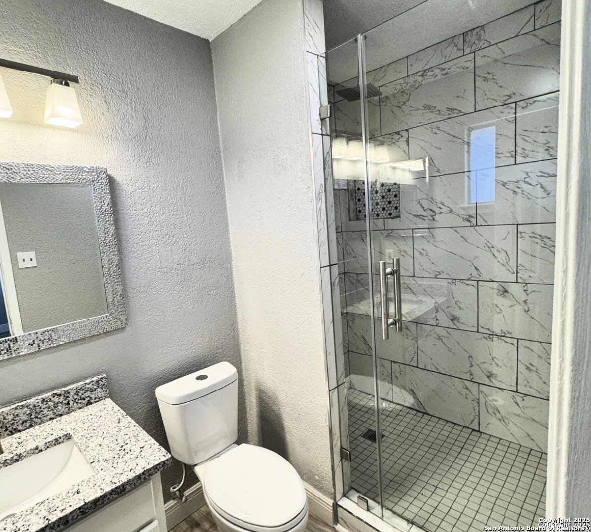 14519 Ridge Meadow Drive San Antonio, TX 78233 - Photo 14 of 25 a bathroom with a granite countertop shower a toilet and a sink