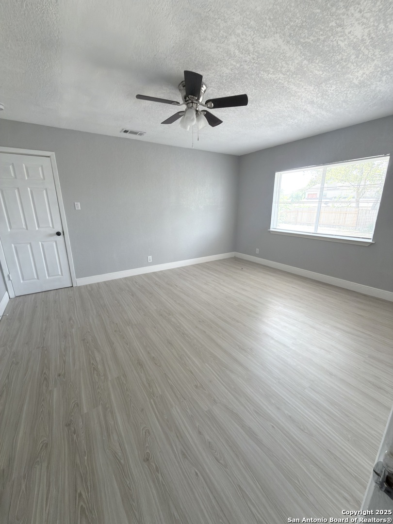 14519 Ridge Meadow Drive San Antonio, TX 78233 - Photo 5 of 25 wooden floor in an empty room with a window