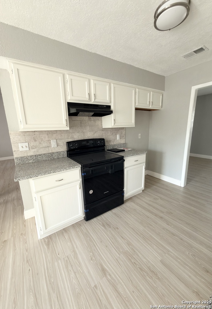 14519 Ridge Meadow Drive San Antonio, TX 78233 - Photo 9 of 25 a large kitchen with stainless steel appliances granite countertop a stove a sink and white cabinets