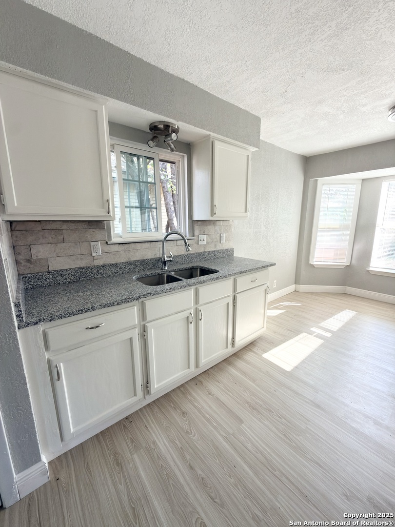 14519 Ridge Meadow Drive San Antonio, TX 78233 - Photo 10 of 25 a kitchen with granite countertop white cabinets sink and window