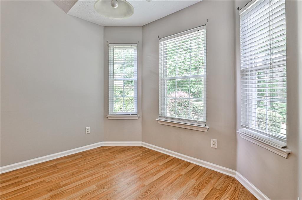 1505 Heatherton Road Dacula, GA 30019 - Photo 13 of 33 a view of an empty room with wooden floor and a window