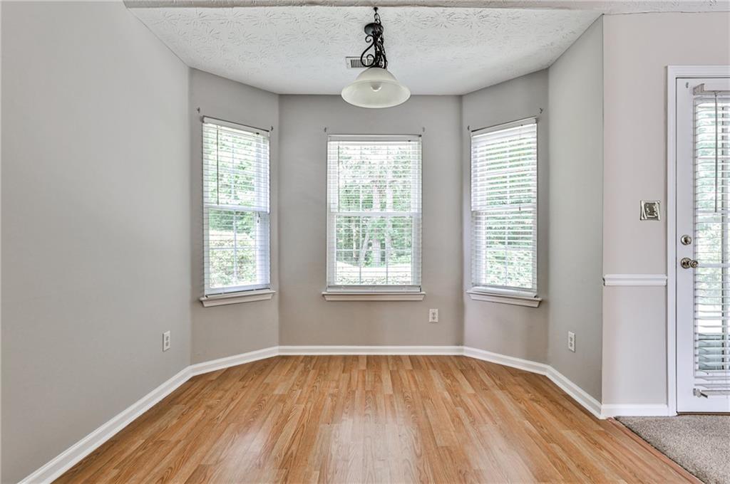 1505 Heatherton Road Dacula, GA 30019 - Photo 14 of 33 a view of an empty room with wooden floor and a window