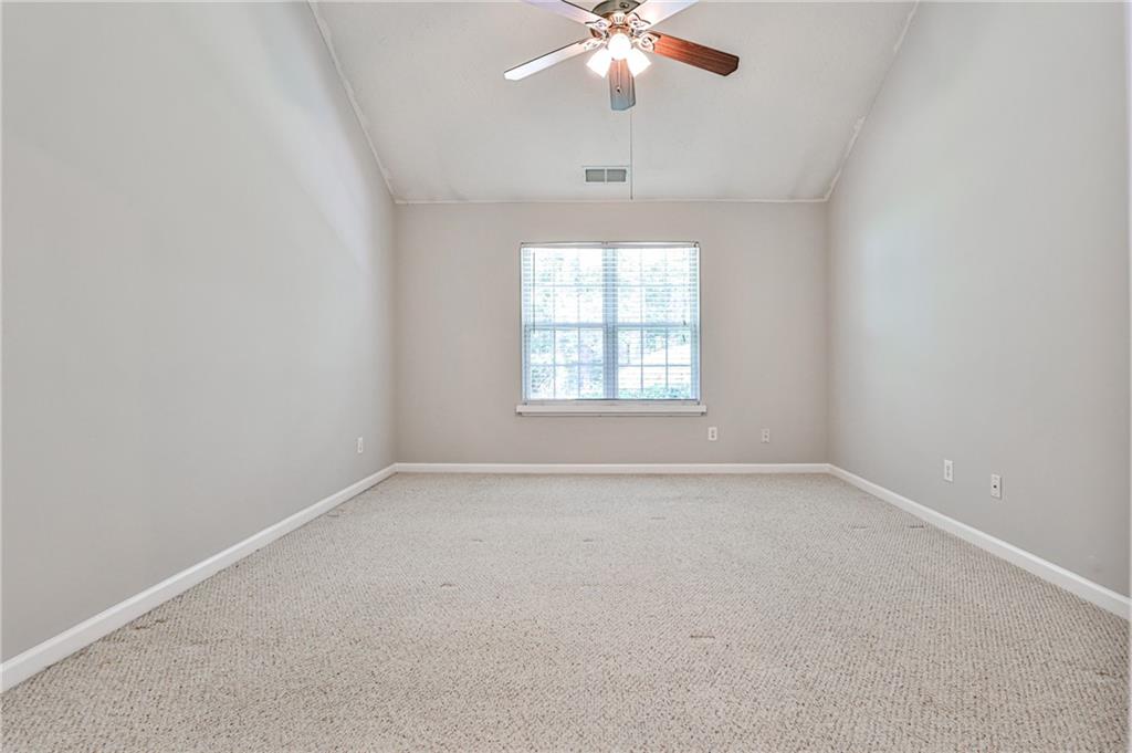 1505 Heatherton Road Dacula, GA 30019 - Photo 16 of 33 an empty room with a chandelier fan and windows