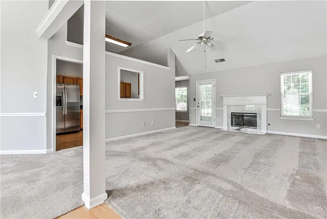 an empty room with windows and fireplace