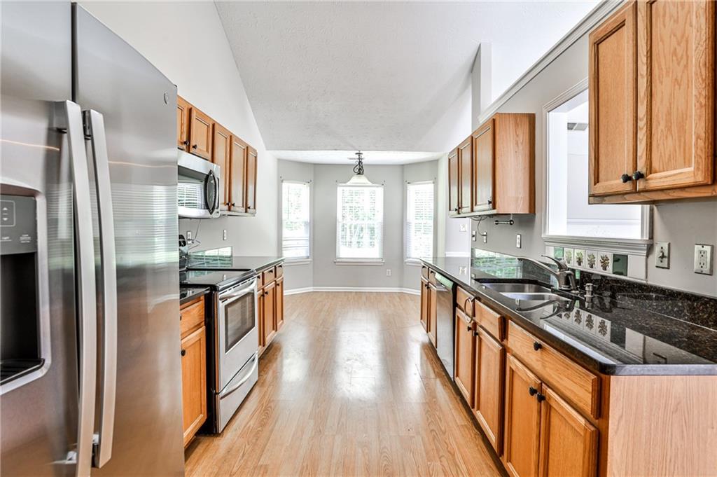 1505 Heatherton Road Dacula, GA 30019 - Photo 7 of 33 a kitchen with stainless steel appliances granite countertop a stove a sink and a refrigerator