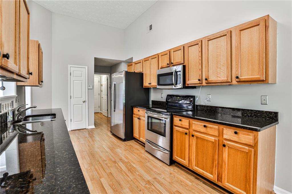 1505 Heatherton Road Dacula, GA 30019 - Photo 8 of 33 a kitchen with stainless steel appliances granite countertop a stove a sink and a refrigerator