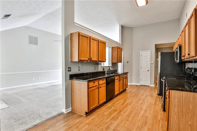 a kitchen with stainless steel appliances granite countertop a stove a sink and a refrigerator
