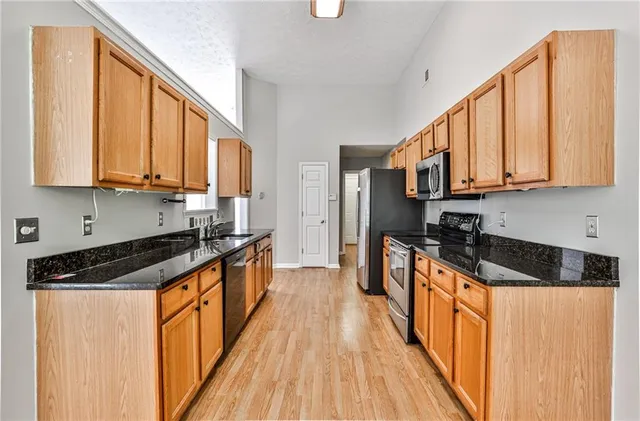 a kitchen with stainless steel appliances granite countertop a stove a sink and a refrigerator