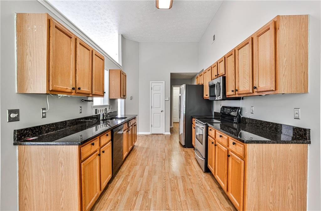 1505 Heatherton Road Dacula, GA 30019 - Photo 10 of 33 a kitchen with stainless steel appliances granite countertop a stove a sink and a refrigerator