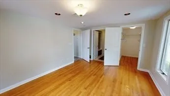a view of a room with wooden floor and a ceiling fan