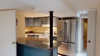 a kitchen with kitchen island a counter top space cabinets and stainless steel appliances