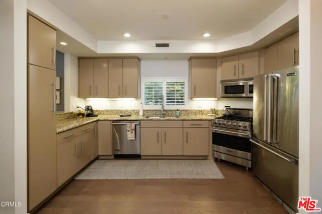 a kitchen with a refrigerator stove top oven a sink and dishwasher