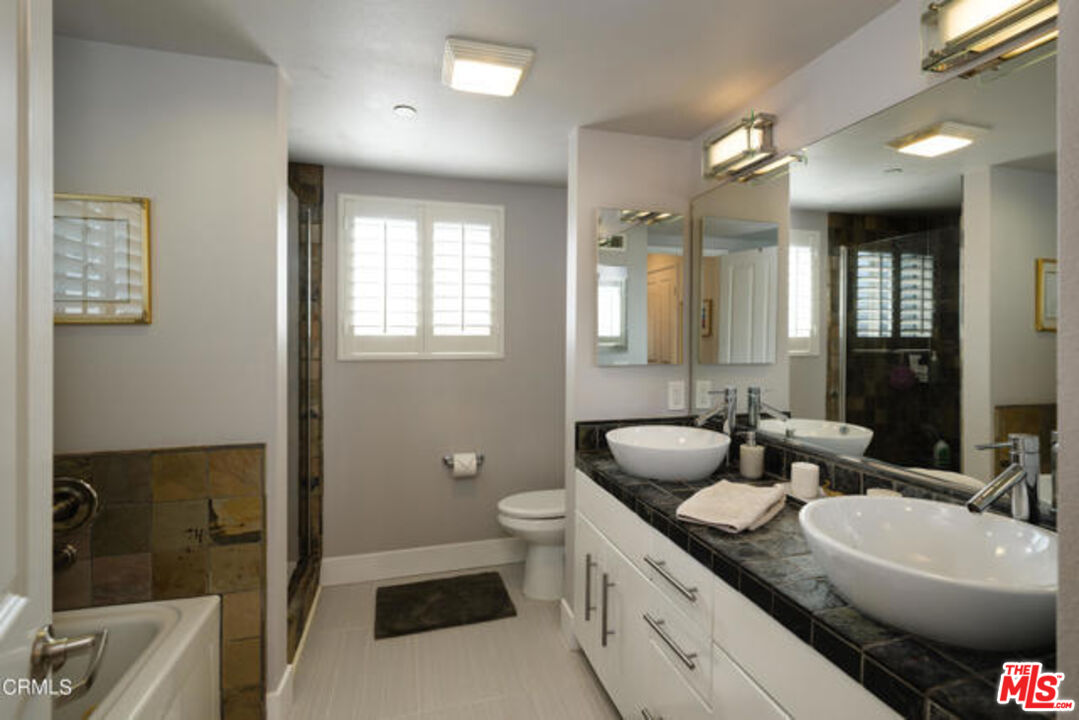 10918 Morrison Street, Unit 12 North Hollywood, CA 91601 - Photo 22 of 28 a bathroom with a double vanity sink toilet mirror and bathtub