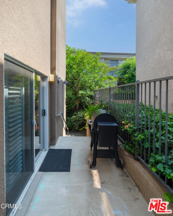 10918 Morrison Street, Unit 12 North Hollywood, CA 91601 - Photo 27 of 28 a porch with a bench next to a yard