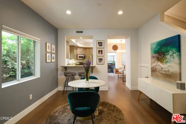 a living room with furniture a window and wooden floor