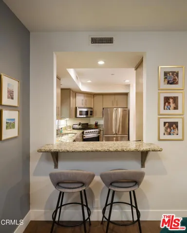 a kitchen with stainless steel appliances a dining table and chairs