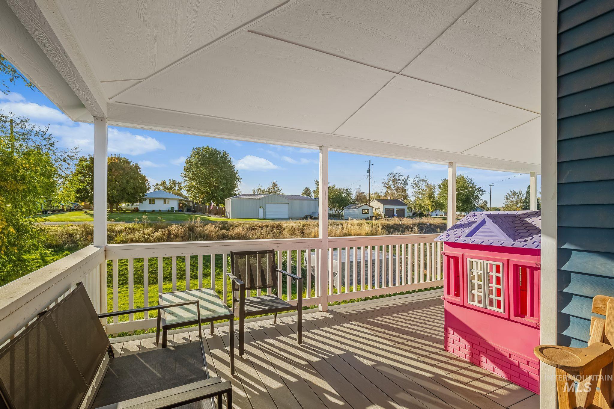 Covered porch with white railings and blue exterior siding