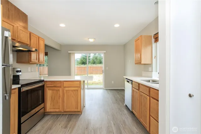 a kitchen with stainless steel appliances granite countertop wooden cabinets sink and stove