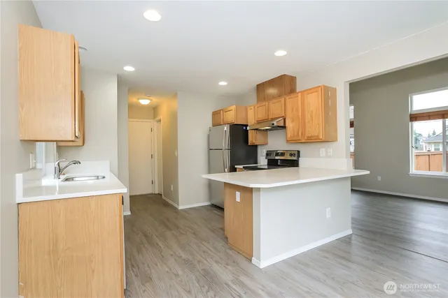 a kitchen with a sink cabinets and wooden floor