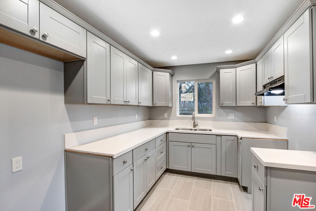 3324 Grampion Road Riverside, CA 92507 - Photo 8 of 11 a kitchen with a sink dishwasher a stove top oven a refrigerator with island and chairs