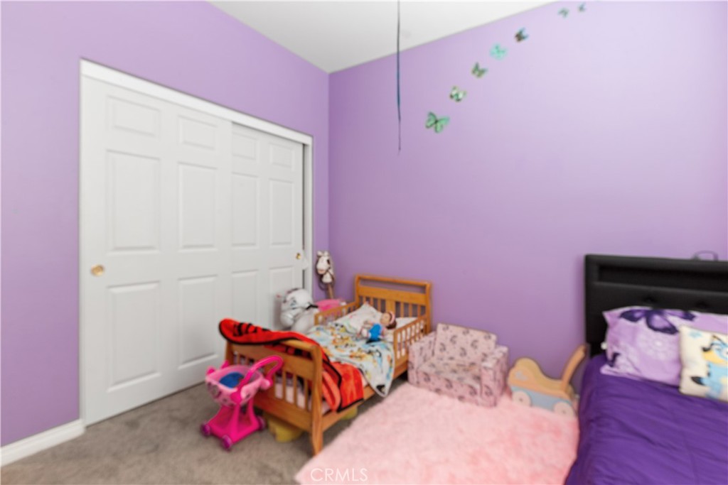11643 Raptor Lane Desert Hot Springs, CA 92240 - Photo 19 of 37 a bedroom with pink walls and a couch