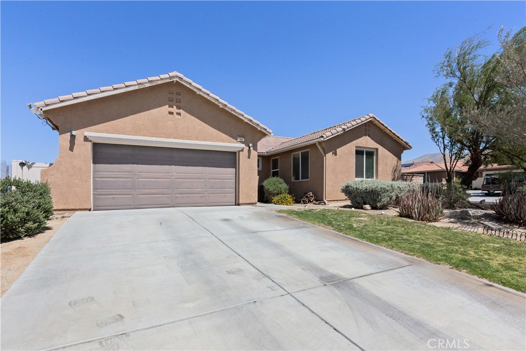 11643 Raptor Lane Desert Hot Springs, CA 92240 - Photo 31 of 37 a front view of a house with a yard and garage
