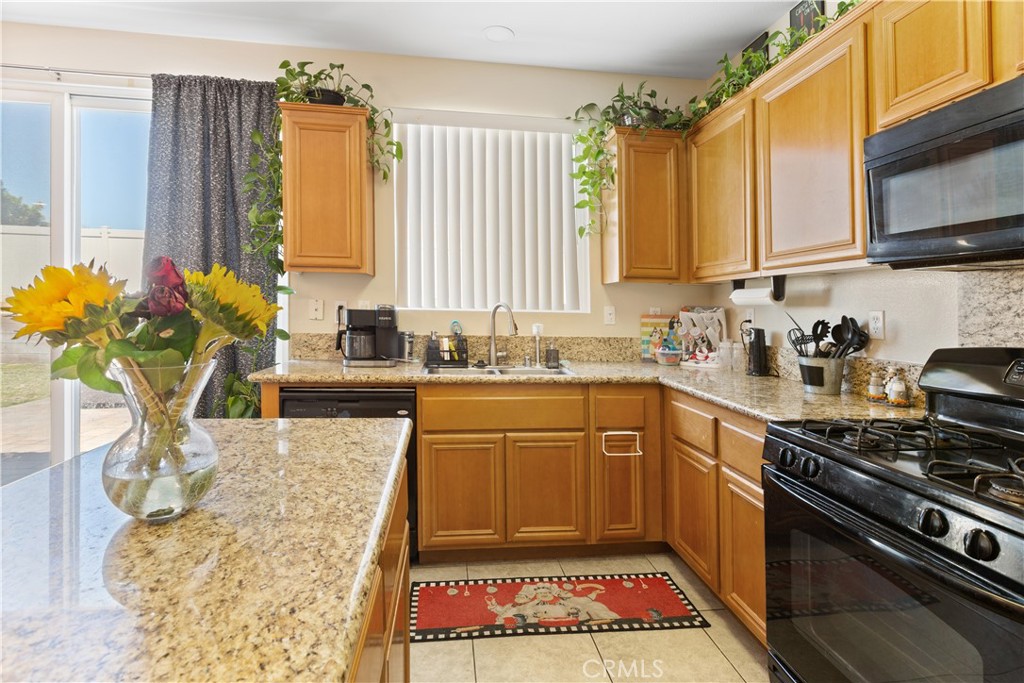 11643 Raptor Lane Desert Hot Springs, CA 92240 - Photo 7 of 37 a kitchen with stainless steel appliances granite countertop a stove a sink and a microwave