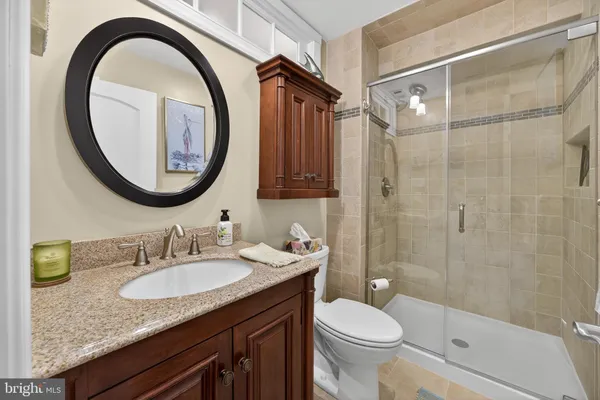 a bathroom with a granite countertop sink toilet and a mirror