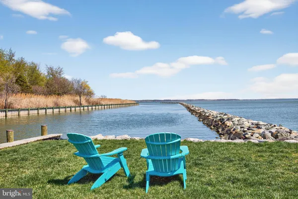 a view of a lake from a balcony with outdoor seating
