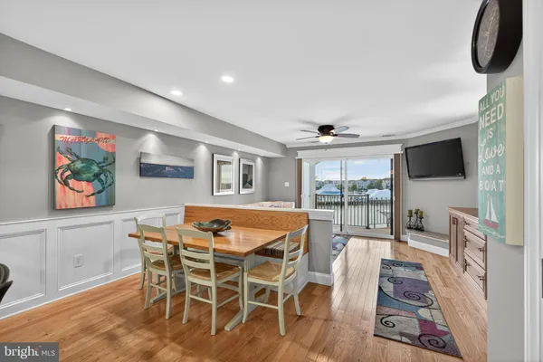 a dining room with furniture wooden floor a painting and a chandelier